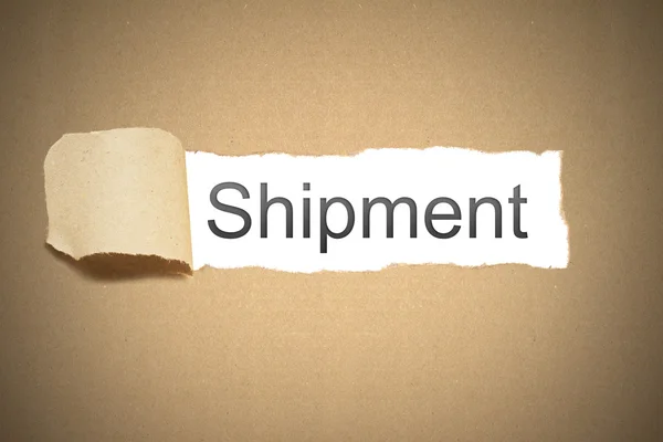 Brown paper torn to reveal shipment — Stock Photo, Image