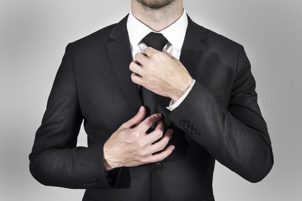 businessman correcting his tie