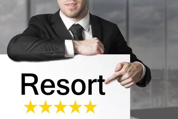 Empresario señalando en cartel resort cinco estrellas —  Fotos de Stock