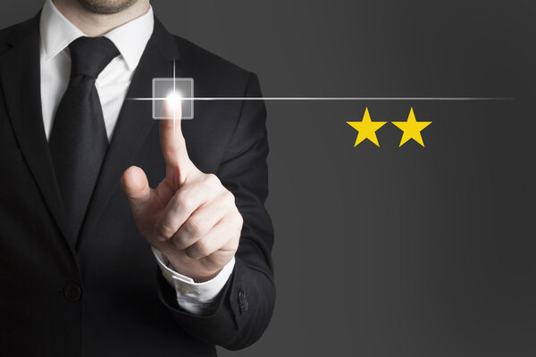 businessman pushing touchscreen button two rating stars