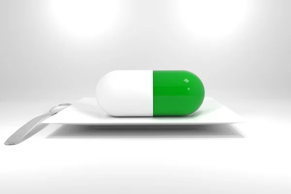 Large size green pill on white plate — Zdjęcie stockowe