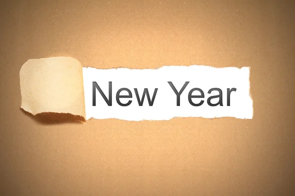 Brown paper torn to reveal new year — Stock Photo, Image