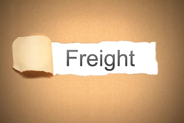 Brown paper torn to reveal Freight — Stock Photo, Image