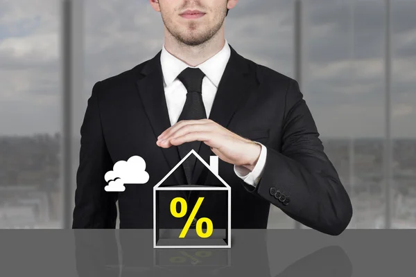 Businessman holding protective hand above building percentage sy — Stock Photo, Image