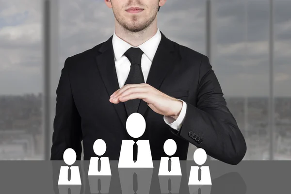 Businessman holding protective hand above employee staff — Stock Photo, Image