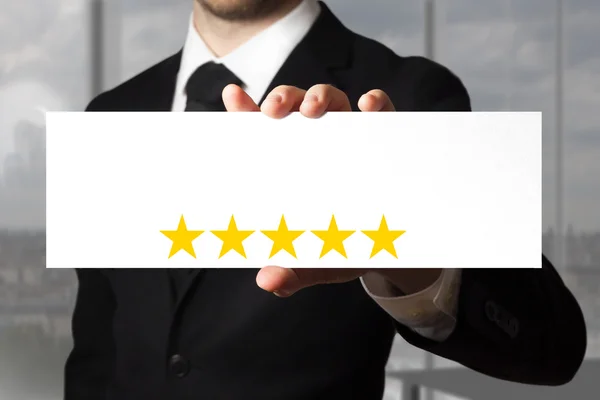 Businessman holding sign five golden stars — Stock Photo, Image