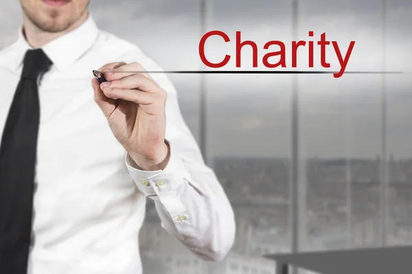 Business man in office writing charity in the air — стоковое фото