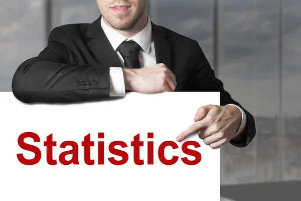 Homme d'affaires pointant sur les statistiques des signes — Photo