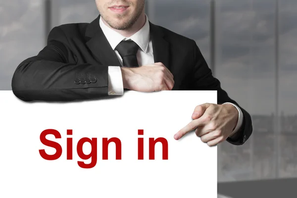 Businessman pointing on sign in — Stock Photo, Image
