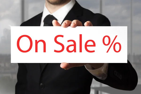 Podnikatel drží ceduli na prodej symbol procenta — Stock fotografie