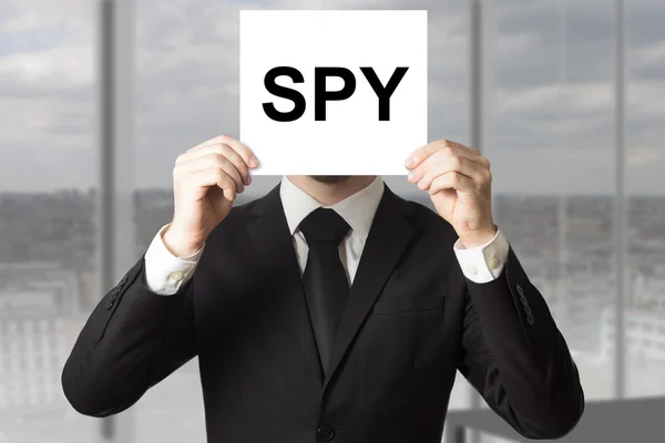 Uomo d'affari nascosto faccia dietro segno spia — Foto Stock