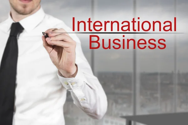 Affärsman skriver internationella affärer i luften — Stockfoto
