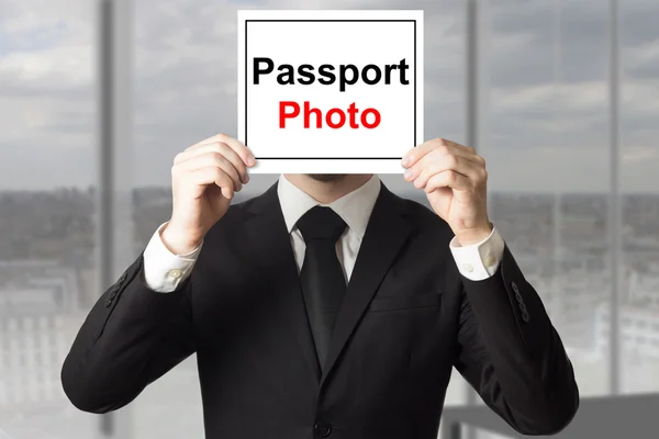 Hombre de negocios ocultar la cara detrás de la foto de pasaporte signo — Foto de Stock