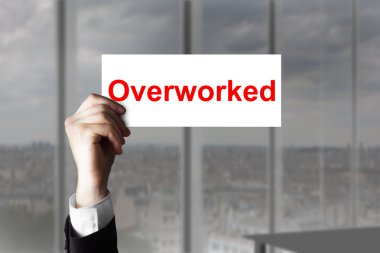 hand holding up sign overworked