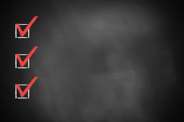 Three red marked checkboxes on a black chalkboard — Stock Photo, Image