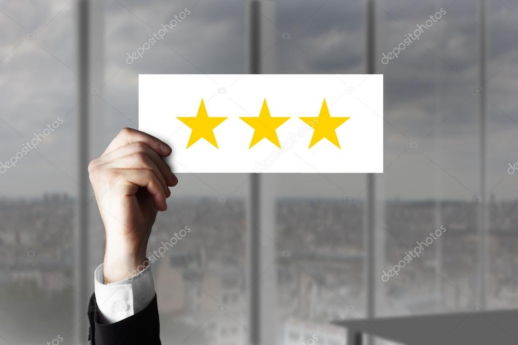 hand holding up small sign three rating stars