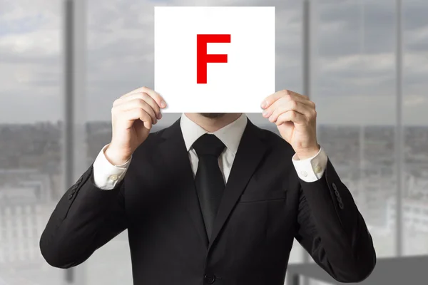 Επιχειρηματία στο κοστούμι που κρατά ψηλά το σημάδι με το γράμμα f — Φωτογραφία Αρχείου