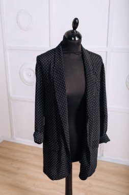 Atölyede siyah ceketli bir kadın manken.