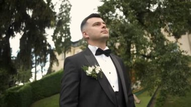 Takım elbiseli genç esmer doğada yürüyor. Motivasyon, Başarı. Birincide yansımalar. Buluşmayı bekliyor.