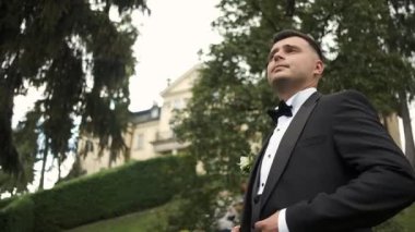 Takım elbiseli genç esmer doğada yürüyor. Motivasyon, Başarı. Birincide yansımalar. Buluşmayı bekliyor.