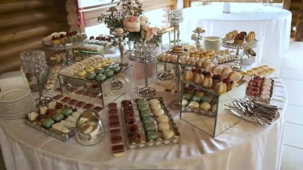 Buffet con delicias en la boda. Confitería. Macarrones — Vídeos de Stock