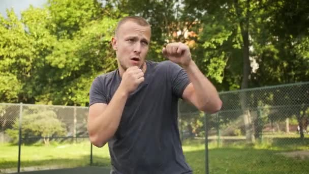 La boxe. Le jeune homme s'entraîne sur un terrain de sport. Sports et santé — Video