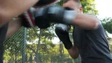 Boks yapıyorum. Beyaz görünümlü genç bir adam antrenmanlarını sokakta yapıyor. Spor ve sağlık