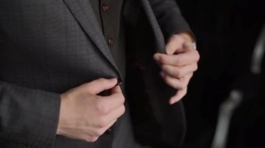 Ceketinin düğmelerini ilikleyen takım elbiseli bir adamın portresi. İş toplantısı