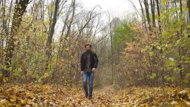 Um homem brutal caminha na floresta e agita a mão emocionalmente. Depressão. Difícil em dias ruins — Vídeo de Stock