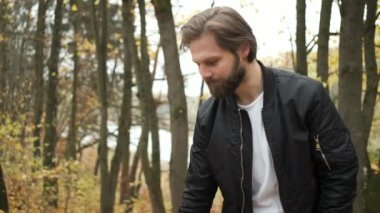 Sonbahar parkında köpeği gezdiren vahşi esmer. Bir salgın sırasında doğada kendini soyutlama