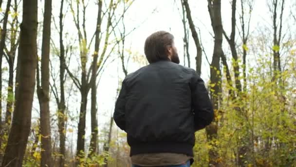 Portrét brutálního fotografa kráčejícího podzimním lesem s fotoaparátem a fotografujícího krajinu zlatého podzimu — Stock video
