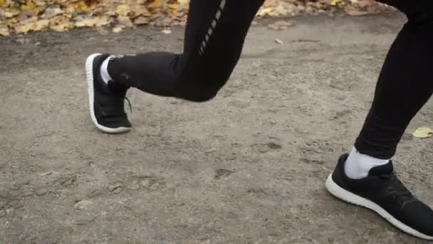 Retrato de atletas pernas no parque fazendo exercícios de aquecimento lunges antes de correr — Vídeo de Stock