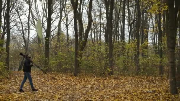Ontvangen fotograaf wandelend in het herfstbos met een camera en natuurlandschappen van de gouden herfst fotograferend — Stockvideo