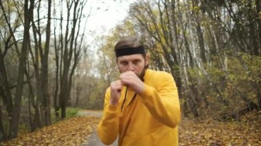 Parkta kameranın önünde boks yapan bir sporcu. Isınma ve motivasyon, hedef, disiplin