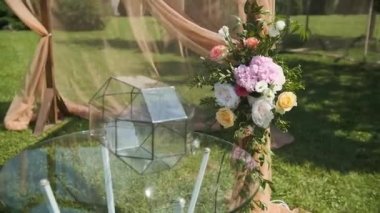 Zarflar için şeffaf bir kutu. Düğün dekoru. Güzel bir düğün kemeri. Bahçede taze çiçekler var. Güneşli bir yaz gününde.