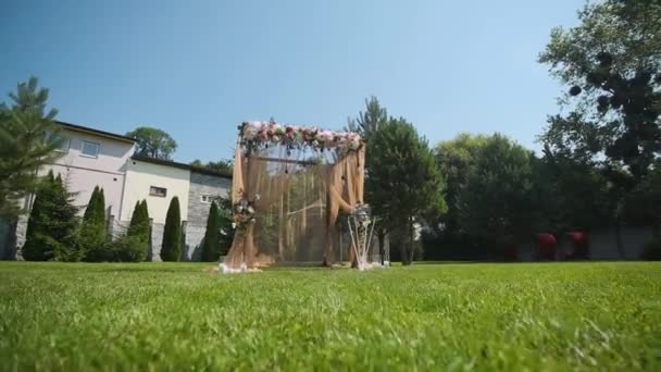 Huwelijksdecor. Prachtige trouwboog met verse bloemen in de tuin. Prachtige bruiloft — Stockvideo