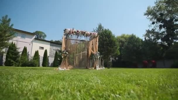 Decoração de casamento. Arco de casamento bonito com flores frescas no jardim em um dia de casamento bonito ensolarado de verão — Vídeo de Stock