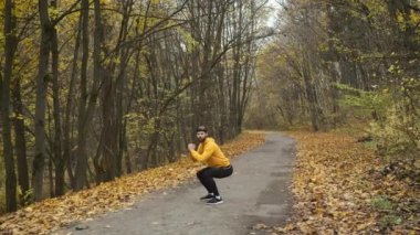 Sonbahar parkında sarı bir tişörtle beyaz tenli bir sporcu. Motivasyon, spor ve yarışmalara hazırlık