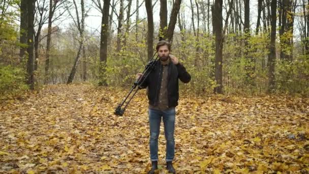 Fotógrafo concebido caminando por el bosque otoñal con una cámara fotográfica y fotografiando los paisajes naturales del dorado otoño. Investigación e invención de contenidos — Vídeo de stock