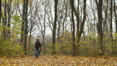 Tasarlanmış fotoğrafçı, elinde bir kamerayla sonbahar ormanında yürüyor ve altın sonbaharın doğal manzaralarını fotoğraflıyor. İçeriğin araştırılması ve icadı
