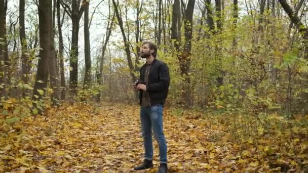 Fotógrafo concebido caminhando na floresta de outono com uma câmera e fotografando as paisagens naturais do outono dourado. Investigação e invenção do conteúdo — Vídeo de Stock