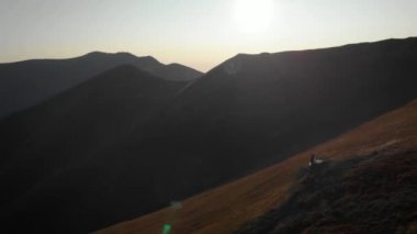 Beyaz elbiseli mutlu bir gelin bir dağın tepesinde ve bir uçurumda duruyor. İnanılmaz doğa ve kel dağlar. Ormanların tahrip edilmesi, ekoloji, sel