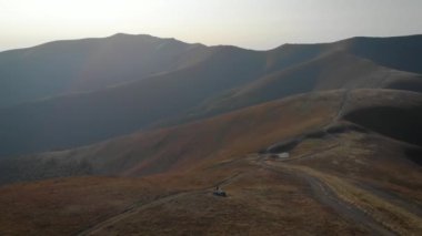 Beyaz elbiseli mutlu bir gelin bir dağın tepesinde ve bir uçurumda duruyor. İnanılmaz doğa ve kel dağlar. Ormanların tahrip edilmesi, ekoloji, sel