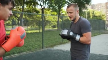 Boks yapıyorum. Beyaz görünümlü genç bir adam antrenmanlarını sokakta yapıyor. Spor ve sağlık