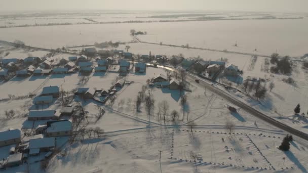 Lot dronem nad ukraińską osadą pokrytą śniegiem. Zimowa bajka. Zachód słońca w mroźną zimę — Wideo stockowe