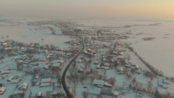 드론은 우크라이나 눈덮인 마을 상공을 비행 한다. 겨울의 동화. 서리가 내리는 겨울의 일몰 — 비디오