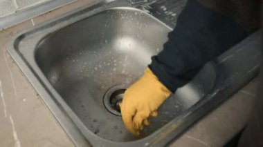 Sarı eldivenli bir süngerle lavaboyu yıkamak. Daireyi temizliyorum. Hızlandırılmış çerçeve