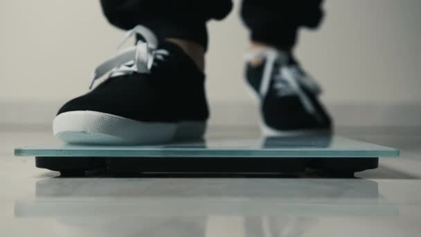 Nahaufnahme der Beine, die auf elektronisches Gewicht kommen und ihr gesundes Sportleben kontrollieren — Stockvideo