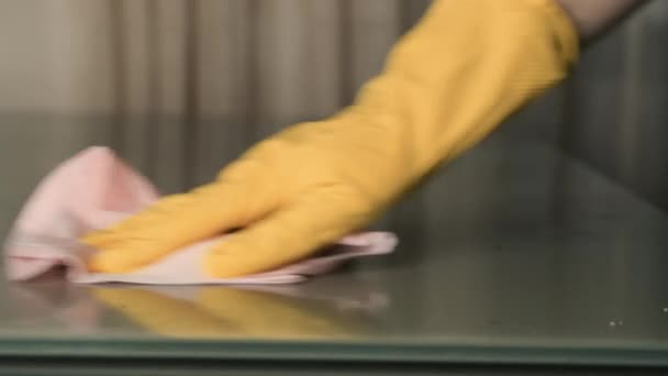 Hand in Hand mit gelben Handschuhen Desinfektionsmittel und wischen die Oberfläche mit einem rosa Tuch. Reinigung und Kontrolle der Pandemie — Stockvideo