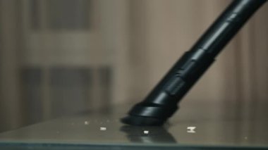 Masadaki tozu kaldıran bir elektrik süpürgesinin yakın çekimi.